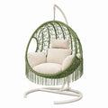 Sedia a dondolo sospesa in vimini verde con cuscini in poliestere beige e supporto in metallo